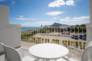 Un balcón con mesa y sillas y el mar. en Hotel Cap Negret, en Altea