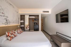 a bedroom with a white bed and a tv at Hotel Cap Negret in Altea