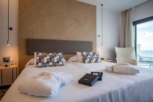 a hotel room with a bed with towels on it at Hotel Cap Negret in Altea