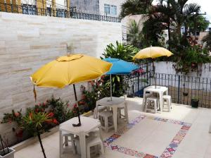 two yellow and blue umbrellas on a patio at Casa de Mainha Friendly Hostel in Salvador