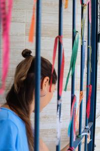 Une femme qui regarde des cerfs-volants accrochés sur un mur dans l'établissement Casa de Mainha Friendly Hostel, à Salvador