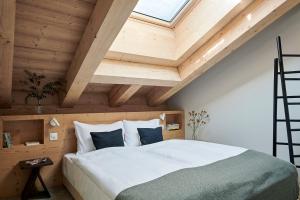 a bedroom with a large bed with a wooden ceiling at Carina - Design&Lifestyle hotel in Zermatt