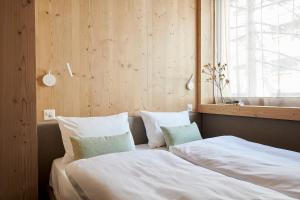 a bedroom with two beds and a window at Carina - Design&Lifestyle hotel in Zermatt