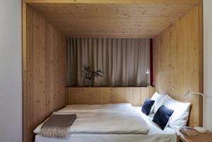 a bedroom with a large bed with a wooden wall at Carina - Design&Lifestyle hotel in Zermatt