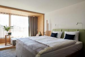 a bedroom with a large bed and a large window at Carina - Design&Lifestyle hotel in Zermatt