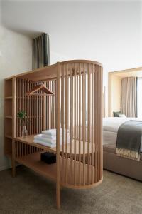 a wooden crib in a bedroom with a bed at Carina - Design&Lifestyle hotel in Zermatt