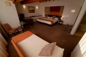 a hotel room with a bed, chair, and nightstand at Rochester Calafate in El Calafate