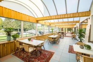 an empty restaurant with tables and chairs and windows at Camping Hitjesvijver in Heerlen