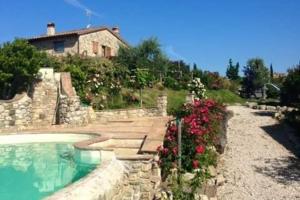 ein Haus auf einem Hügel mit Pool und Blumen in der Unterkunft Casa Lisa al Borgo in Ripalvella