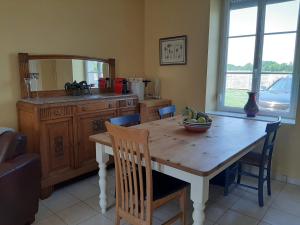 - une cuisine avec une table en bois et un miroir dans l'établissement La Bouyardière, à Saint-Mars-dʼÉgrenne