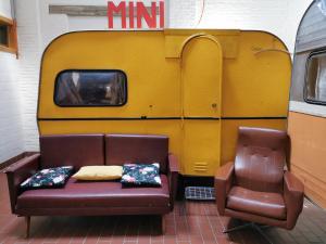 a couch and a chair in front of a trailer at Treck Hostel in Ghent