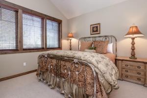 1 dormitorio con 1 cama, vestidor y ventanas en Woodwinds 22, en Mammoth Lakes