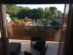 een balkon met stoelen en uitzicht op een achtertuin bij Les Terrasses in Lavérune