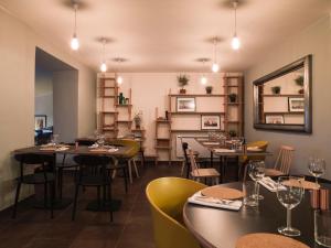 a restaurant with tables and chairs and a mirror at Le Relais de Saint de Ser in Puyloubier