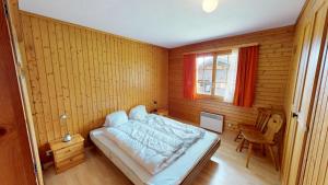 una camera da letto con un letto in una stanza di legno di Triantha TR0 a Blatten bei Naters