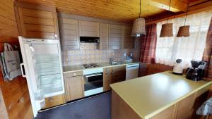 cocina con armarios de madera y nevera blanca en Triantha TR0, en Blatten bei Naters