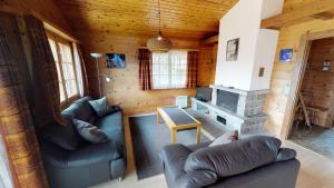 una sala de estar con sofás y una chimenea en una cabaña en Triantha TR0, en Blatten bei Naters