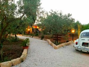 a white car parked in a gravel driveway at Casa Vacanze 'Al Giardino degli Ulivi' in Marinella di Selinunte