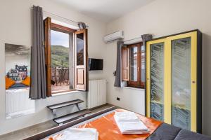 a bedroom with a bed and windows with a view at Etnaglossa in Linguaglossa