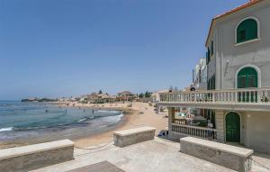 a view of a beach with a building and the ocean at Villa Rosso Corallo in Punta Secca