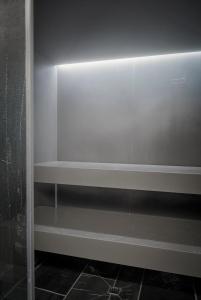 a white shelf in a bathroom with a shower at Carina - Design&Lifestyle hotel in Zermatt