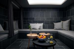 a room with a couch with a bowl of fruit on a table at Carina - Design&Lifestyle hotel in Zermatt