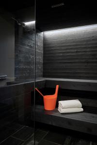 a bathroom with an orange bucket and towels on a bench at Carina - Design&Lifestyle hotel in Zermatt