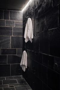 a black bathroom with white towels hanging on a wall at Carina - Design&Lifestyle hotel in Zermatt