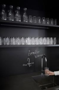 uma fila de copos de vinho numa prateleira por cima de um lavatório em Carina - Design&Lifestyle hotel em Zermatt
