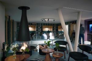a living room with a fireplace and some tables and chairs at Carina - Design&Lifestyle hotel in Zermatt