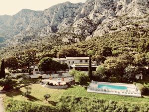 a resort with a swimming pool and a mountain at Le Relais de Saint de Ser in Puyloubier