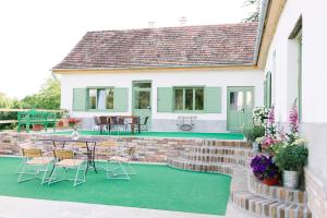 patio ze stołem i krzesłami obok domu w obiekcie Maison BOGArT w mieście Alsobogát