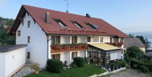 ein weißes Haus mit rotem Dach in der Unterkunft Hotel Haus Seehang in Konstanz