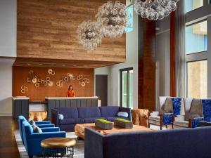 a living room with blue couches and a table at Sonesta Bee Cave Austin Hill Country in Bee Cave