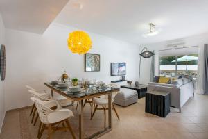 a dining room and living room with a table and chairs at Villas Mar e Brisa in Albufeira