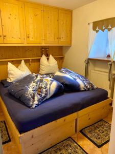 a bed with pillows on it in a room at Dolomites Charme Chalet in Colle Santa Lucia