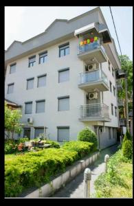 a large white building with balconies and flowers on it at Centar in Vrnjačka Banja
