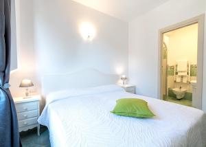 a bedroom with a white bed with a green pillow at O' Lattariello in Amalfi