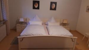 a bedroom with a bed with white sheets and pillows at Ferienwohnung Neckarblick in Heidelberg