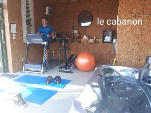 a man in a gym with a treadmill and weights at Auberge Bressane de Buellas in Buellas