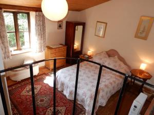 a small bedroom with a bed and a mirror at L'Ecurie in Saint-Ségal