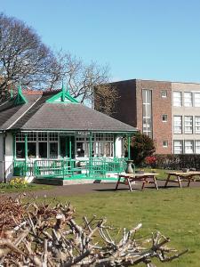 a building with two picnic tables in a park at Ground Floor Apartment in Montrose