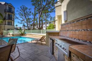 a backyard with a swimming pool and a house with a stove at Beverly Hills Adjacent 2-Bedroom Penthouse in Los Angeles