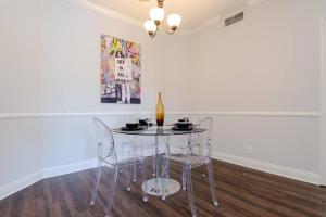 een glazen tafel met 2 stoelen en een fles wijn bij Beverly Hills Adjacent 2-Bedroom Penthouse in Los Angeles