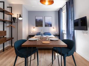 comedor con mesa de madera y sillas azules en Dreamy Flat Lyon - Hyper-Centre - Jean Macé - Studio Cosy, en Lyon