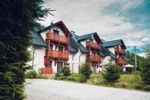 un grand bâtiment avec un balcon en bois dans l'établissement Apartamenty Pod Lipami, à Szczawnica