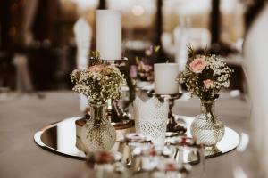 une table avec des vases remplis de fleurs et de bougies dans l'établissement Einhaus, à Möttau