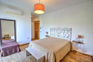 a bedroom with a large bed and a purple chair at Sulle Onde Della Collina in Montecorice