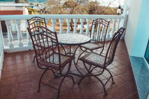 3 sillas y una mesa en el balcón en La Morona Hotel, en Morón de la Frontera
