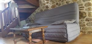 a living room with a couch and a table at Ferme Saint Christophe in Saint-Marcan